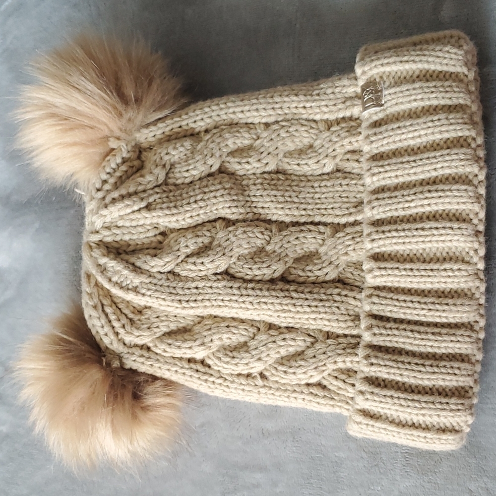 Knit cap with double pompoms.